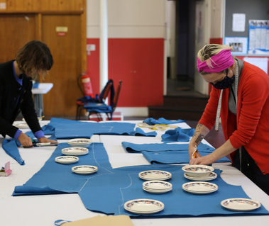 Multiple layers of fabric are being cut.