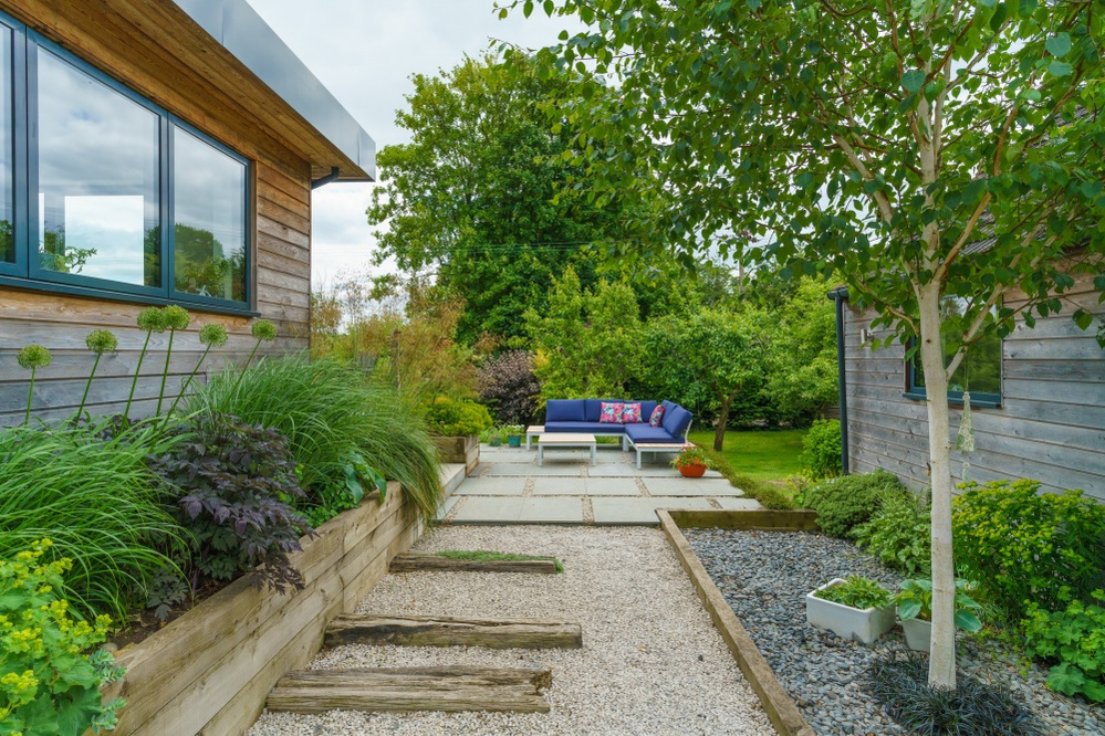 A tough terrace built around a legacy concrete slab. Sleepers and gravel offer variation in width to avoid a potentially nasty corridor.