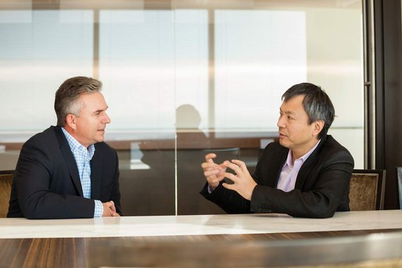 Indoor portrait of two executives having a conversation at a conference table