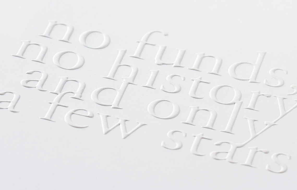 Detail photo of the AIGA SF 25th Year Anniversary book, Inside Front Cover, zoomed in to show the detail of the embossed text stating 