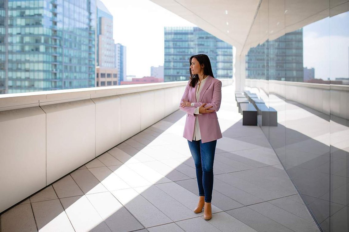 Corporate portraits banner image of a woman standing on a balcony