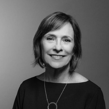 Black and white portrait of Nelle Placek, VP at Lexicon Branding in Sausalito, CA. The background is a seamless backdrop that gradates from light- to dark-gray, and the lighting style on the subject can be described as 