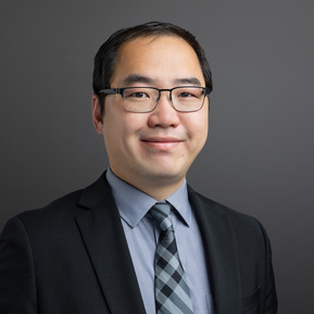 Formal portrait of a Wealth Manager from First Republic Bank against a gray background. The photographic lighting on the face is considered 