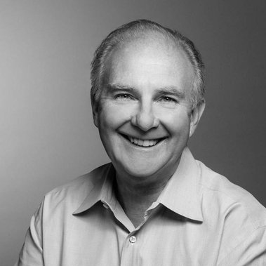 Black and white portrait of David Placek, CEO of Lexicon Branding in Sausalito, CA. The background is a seamless backdrop that gradates from light- to dark-gray, and the lighting style on the subject can be described as 