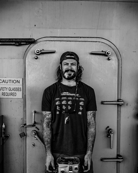 Austin Leathers, San Diego photographer, standing on a ship deck with his underwater photography gear in the Pacific Ocean.