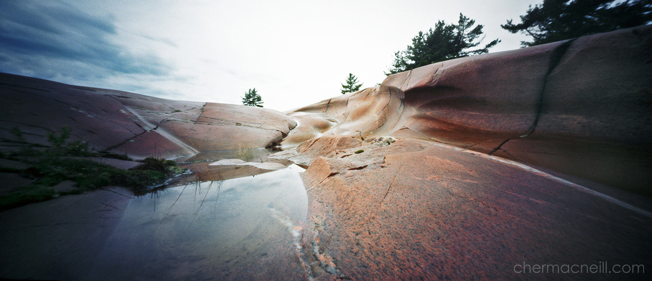 digital scan of a panoramic pinhole photo of waterworn rock in Georgian Bay