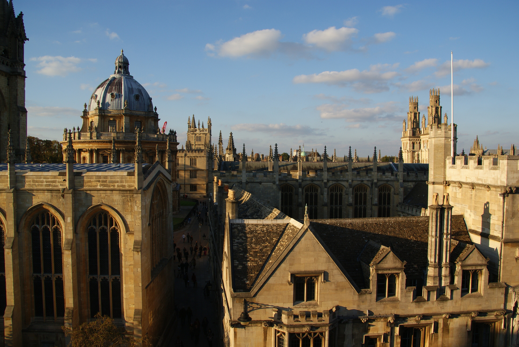 A view over the rooftops of the city of Oxford on a sunny day, with the dome of the Radcliffe Camera in the background.