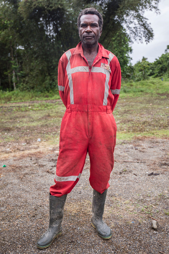 Mimika, Papua, Indonesia. 2018. Edo goes to church in the clothes of a mining company mechanic. Edo got the shirt from an acquaintance who worked at the company. Not many people from the Kamoro Tribe work for mining companies that drastically change their