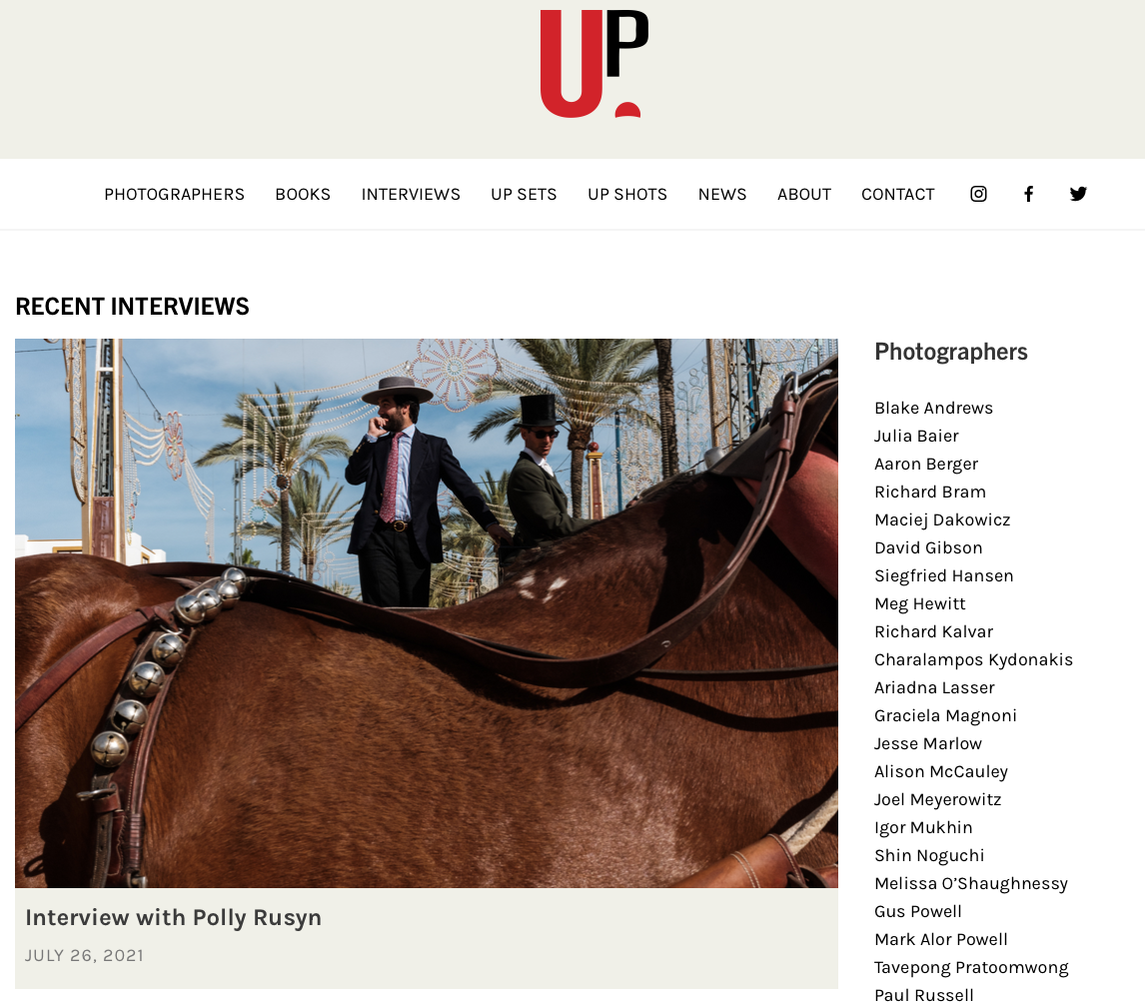 Web homepage featuring logo, and cover photo of two men in hats behind a horse
