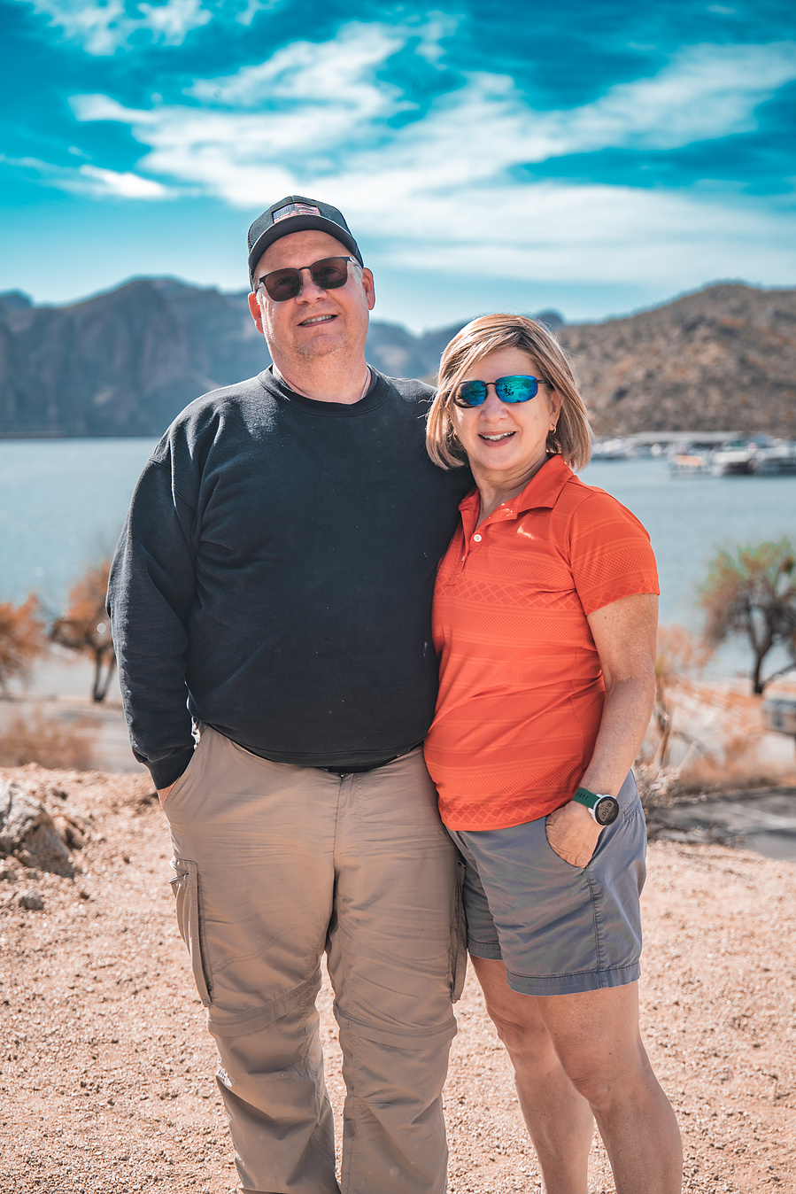 Couple in casual hiking outfits enjoying a scenic view at Saguaro Lake in Arizona.