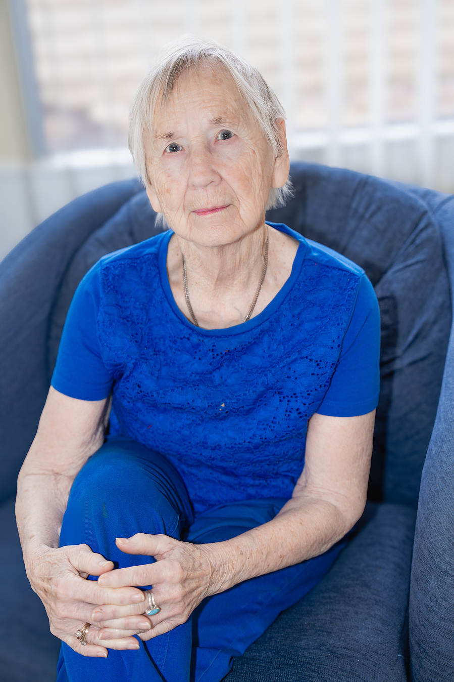     Seated comfortably and smiling softly, this senior woman embodies peaceful aging and personal reflection in a classic lifestyle portrait.

