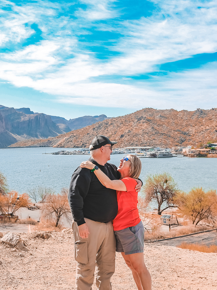 Couple in casual hiking outfits enjoying a scenic view at Saguaro Lake in Arizona.