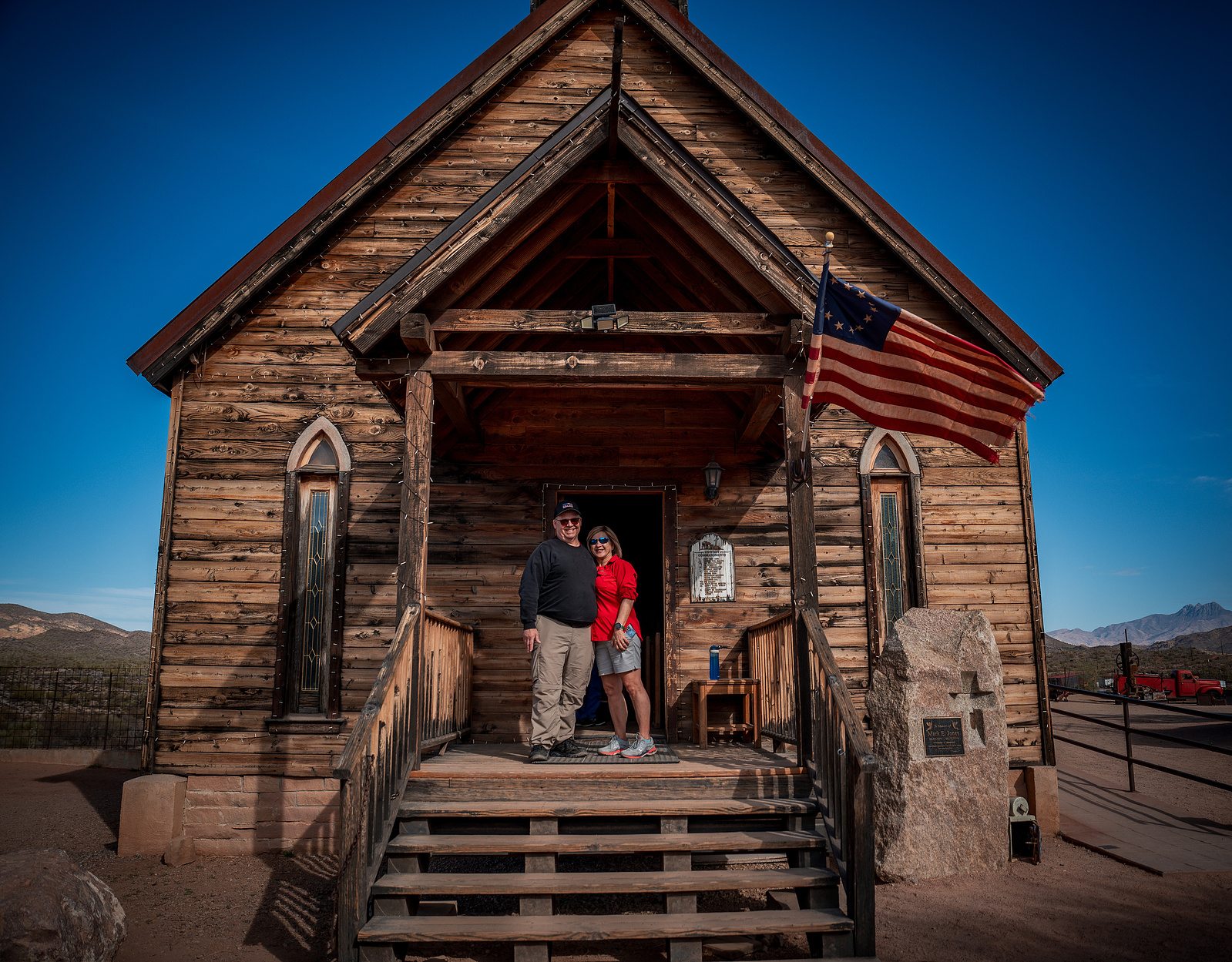 Rustic museum building facade at Goldfield Ghost Town with people posing for a Western-themed photoshoot.