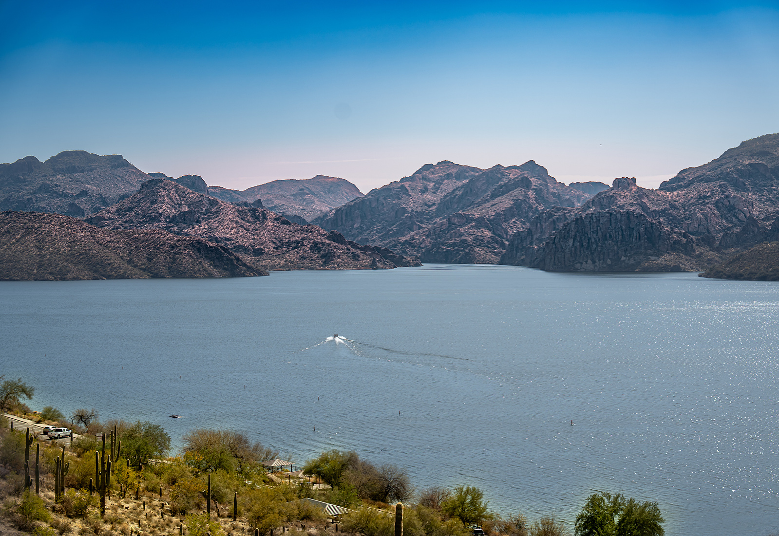 Boating on Saguaro Lake surrounded by dramatic ridgelines and clear blue desert skies.