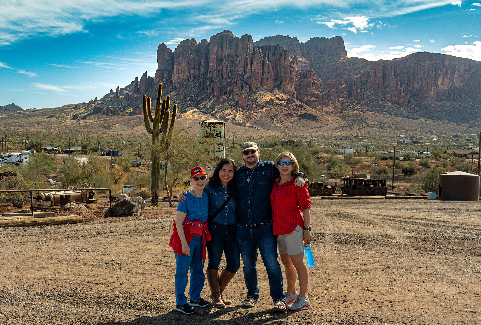 Family-style group photo at Goldfield Ghost Town with dramatic desert mountain views.