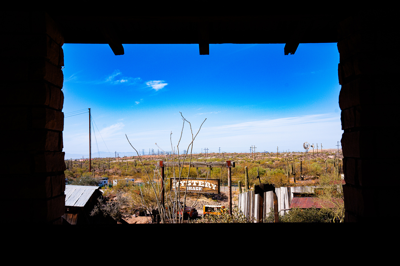 View of Goldfield Ghost Town and Arizona desert framed through a rustic saloon window.