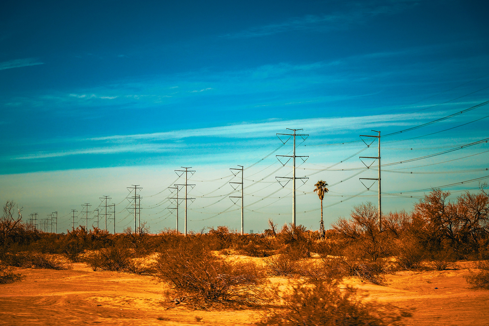 Power lines stretching across the Arizona desert with vibrant skies, blending modern infrastructure with Western landscapes.