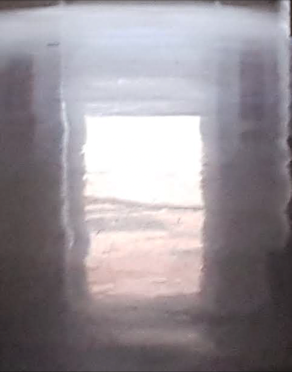 a wobbly reflection of a daylit window on a shiny floor.