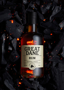 a bottle of rum on a bed of charcoal 