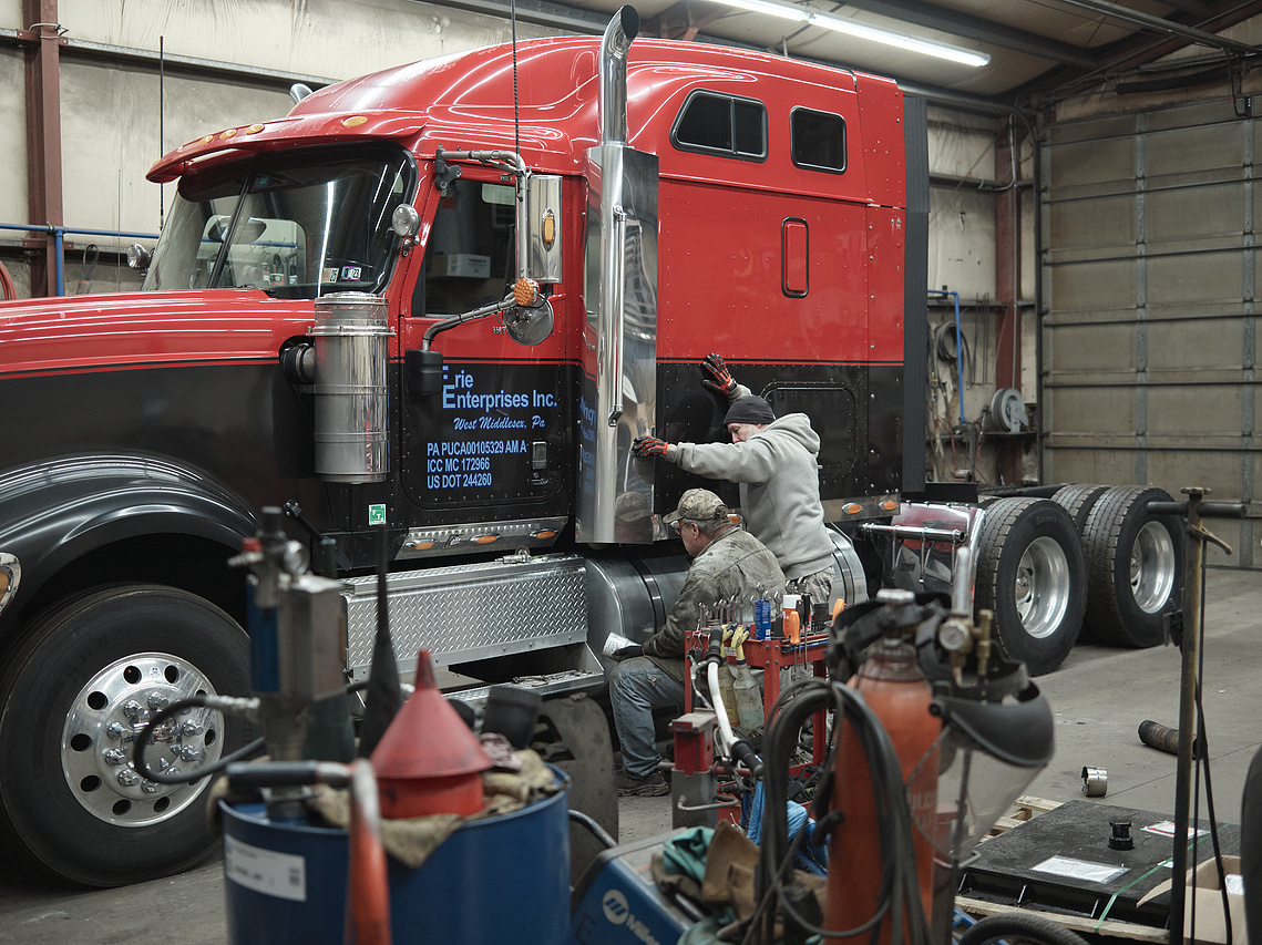 Men work on a semi-truck.