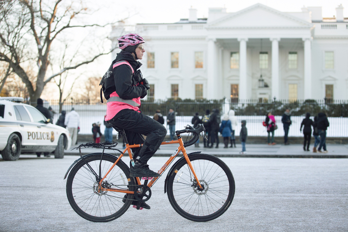 Bike messenger rides in front of the White House in Washington, DC.