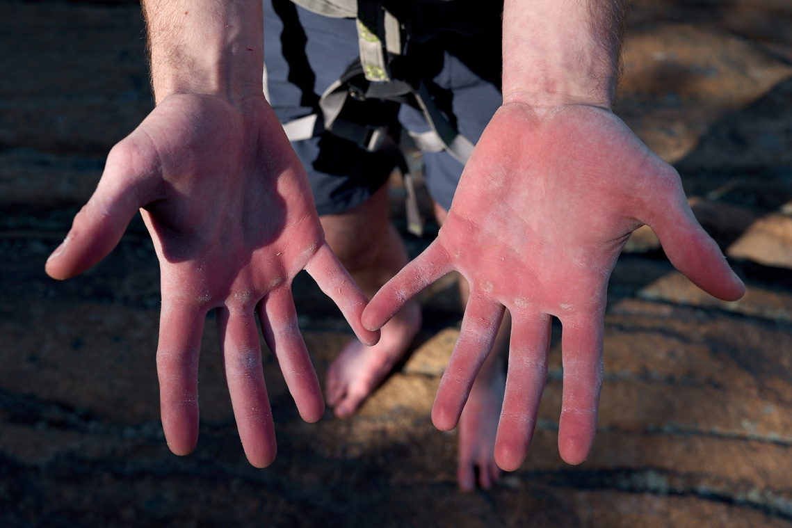 Hands of a rock climber in Acadia National Park