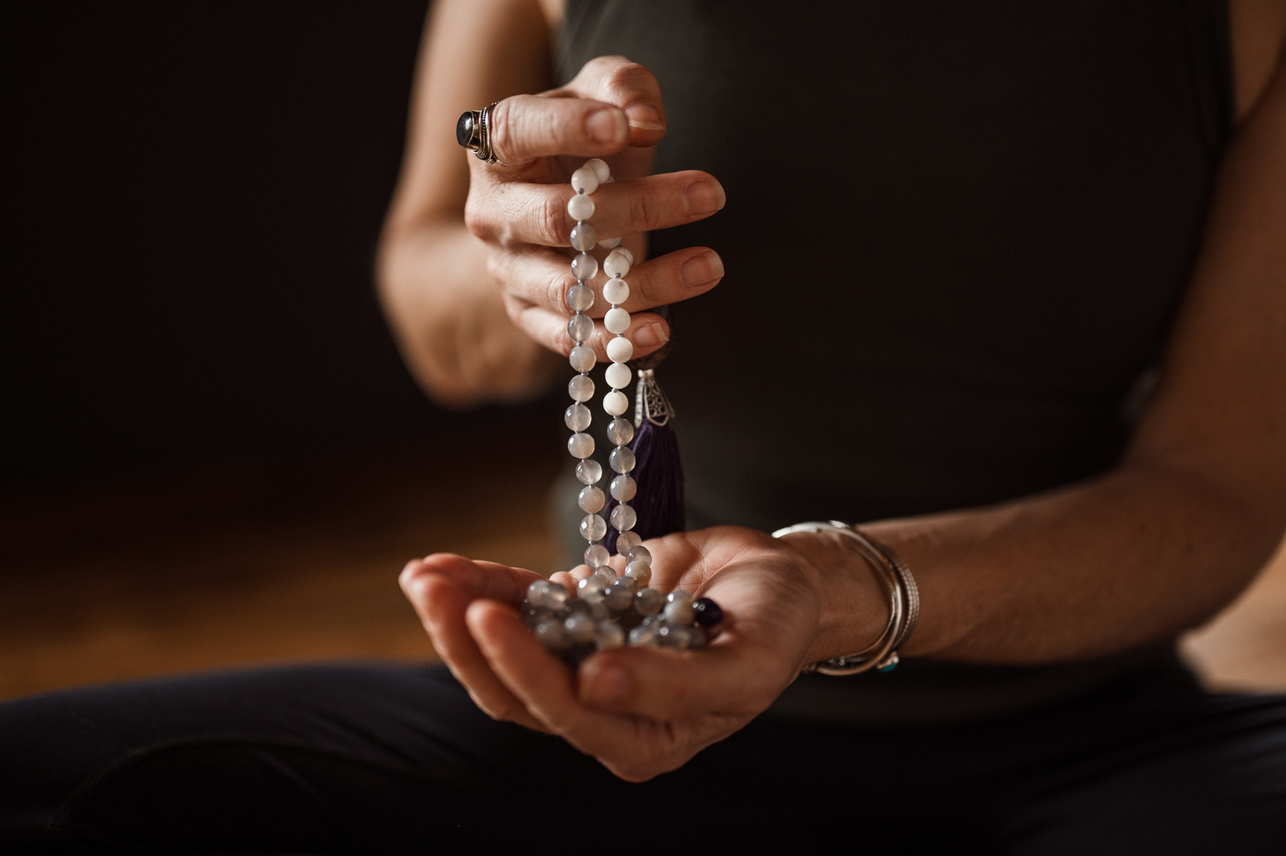 Yoga teacher Jill Barry's hands hold Fat Baby Mala beads in the Norwood photography studio of Boston yoga photographer Korri Leigh Photography