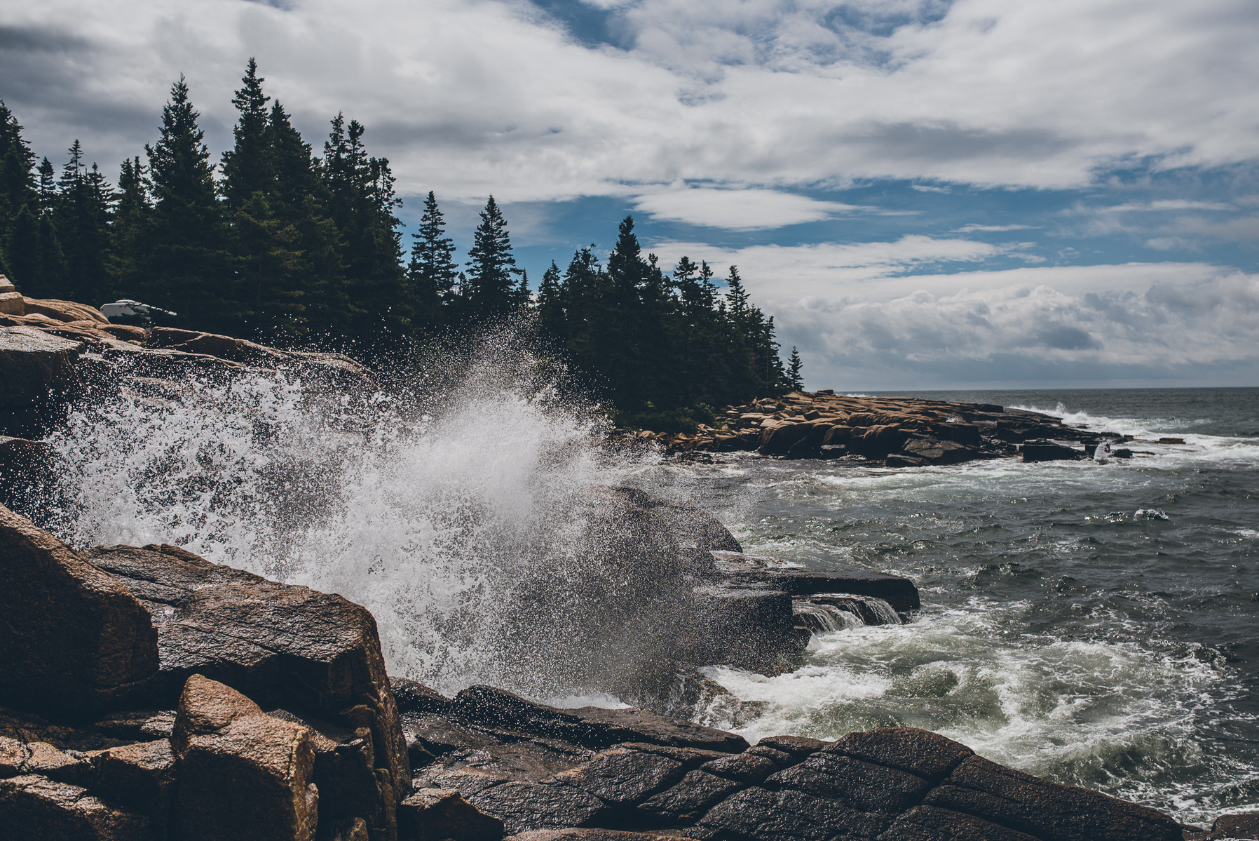 A wave crashes along the rocky Maine coast in Acadia National Park taken by Boston landscape photographer Korri Leigh Crowley
