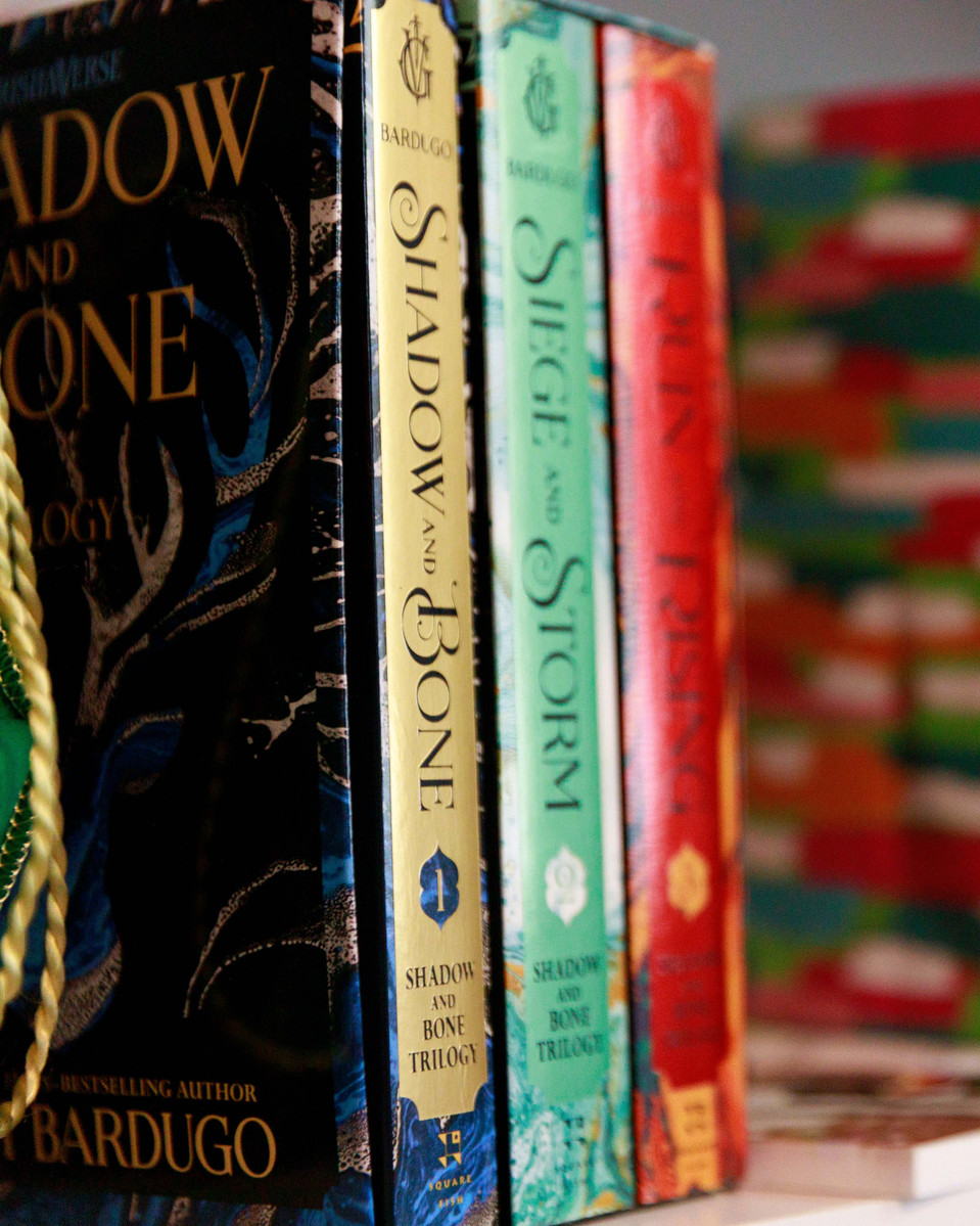 Colorful books sit on a shelf.