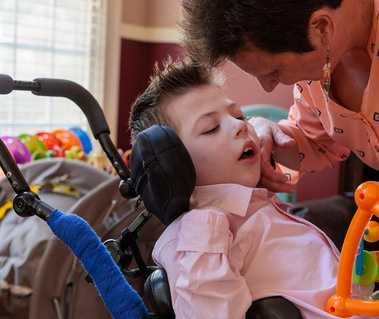 Mother looks at a young boy in a wheelchair.