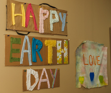 Earth Day artwork hangs on a wall next to a small sign that says LOVE.