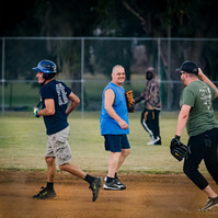 Men run across the field during a baseball game.