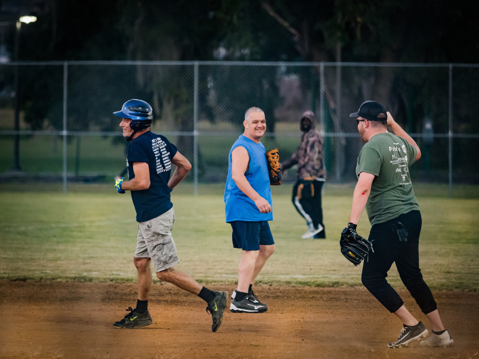 Men run across the field during a baseball game.
