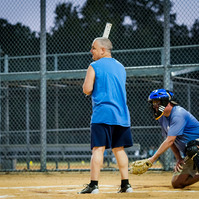 A man stands at home base ready to hit the ball.