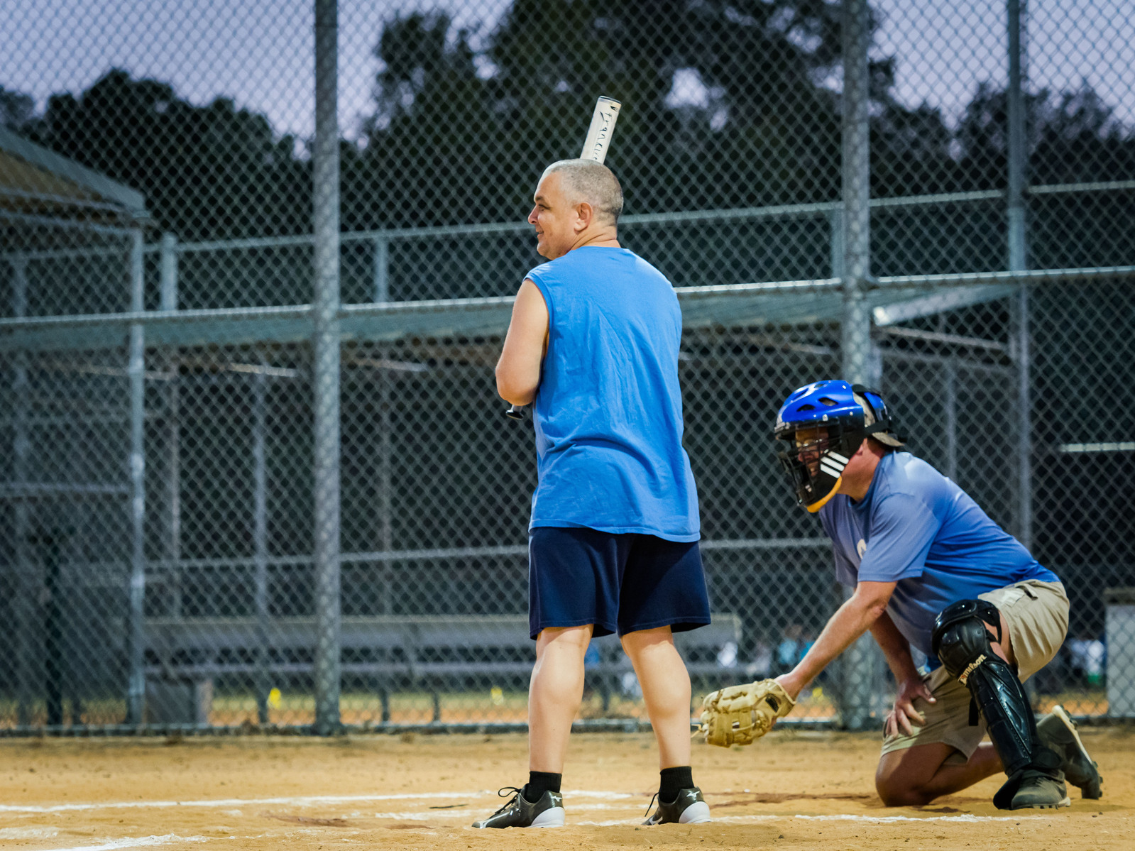 A man stands at home base ready to hit the ball.