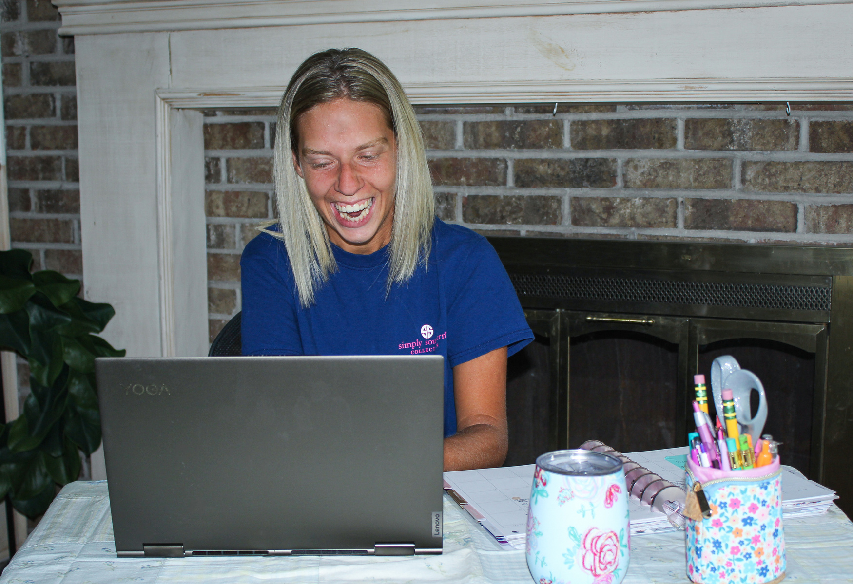 A blond woman sits in front of a laptop computer.  