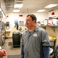 A young man is shown standing next to his boss. 
