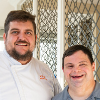 A young man is shown standing next to his boss. 