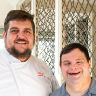 A young man is shown standing next to his boss. 