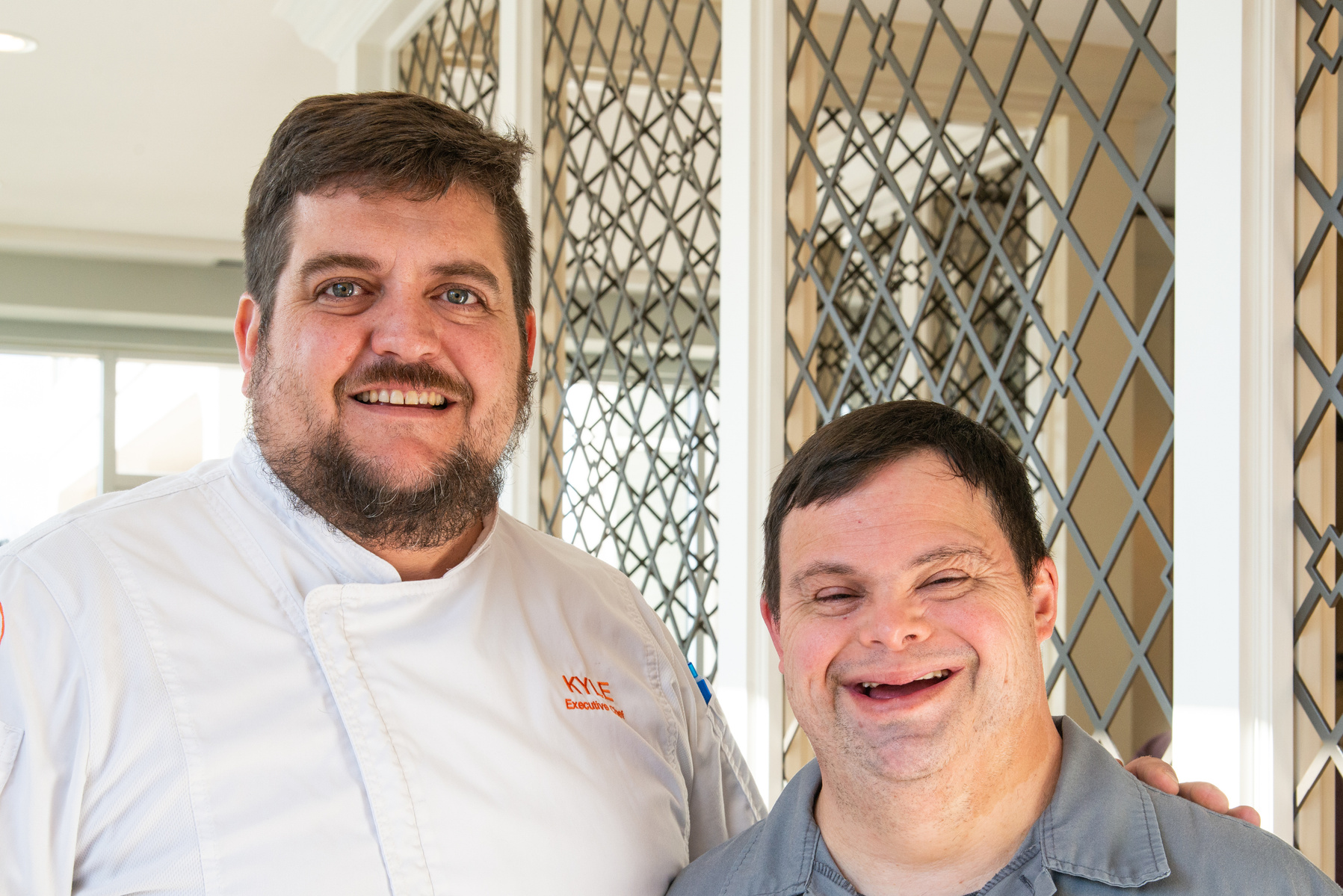 A young man is shown standing next to his boss. 