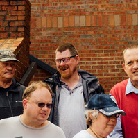 Group from the Dream Weavers stands on a brick staircase. 