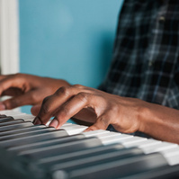 Hands are shown playing a piano.