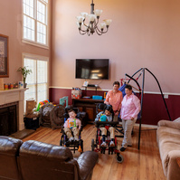 A family stands in their large living room.