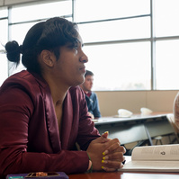 An African American female college student participates in a university class. 