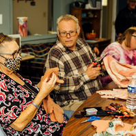 Members of the Dream Weavers sit around a table and talk. 