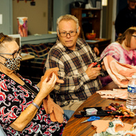 Members of the Dream Weavers sit around a table and talk. 