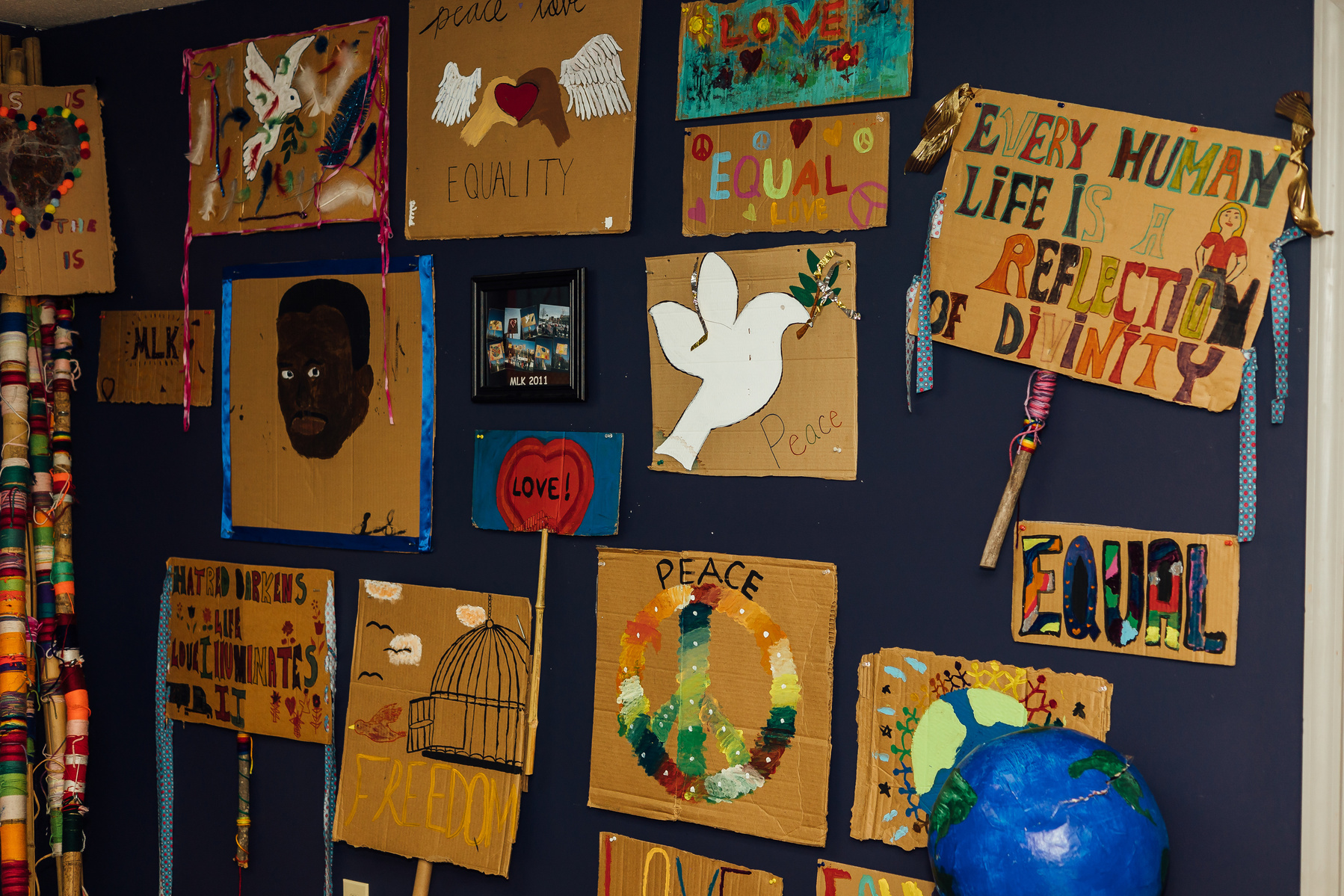 Pieces of Dream Weaver artwork hangs on a dark blue wall.