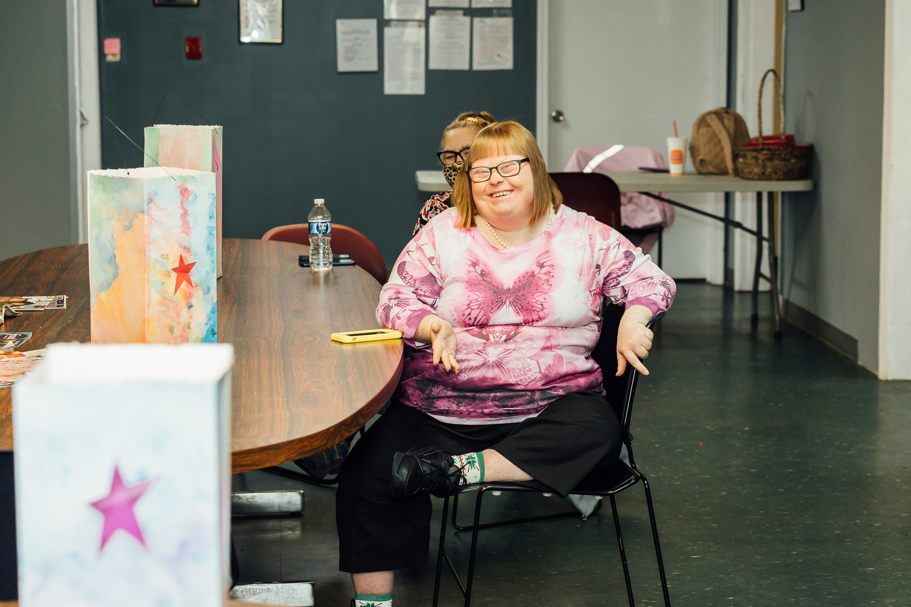 Dream Weaver member sits at a table wearing a pink shirt.