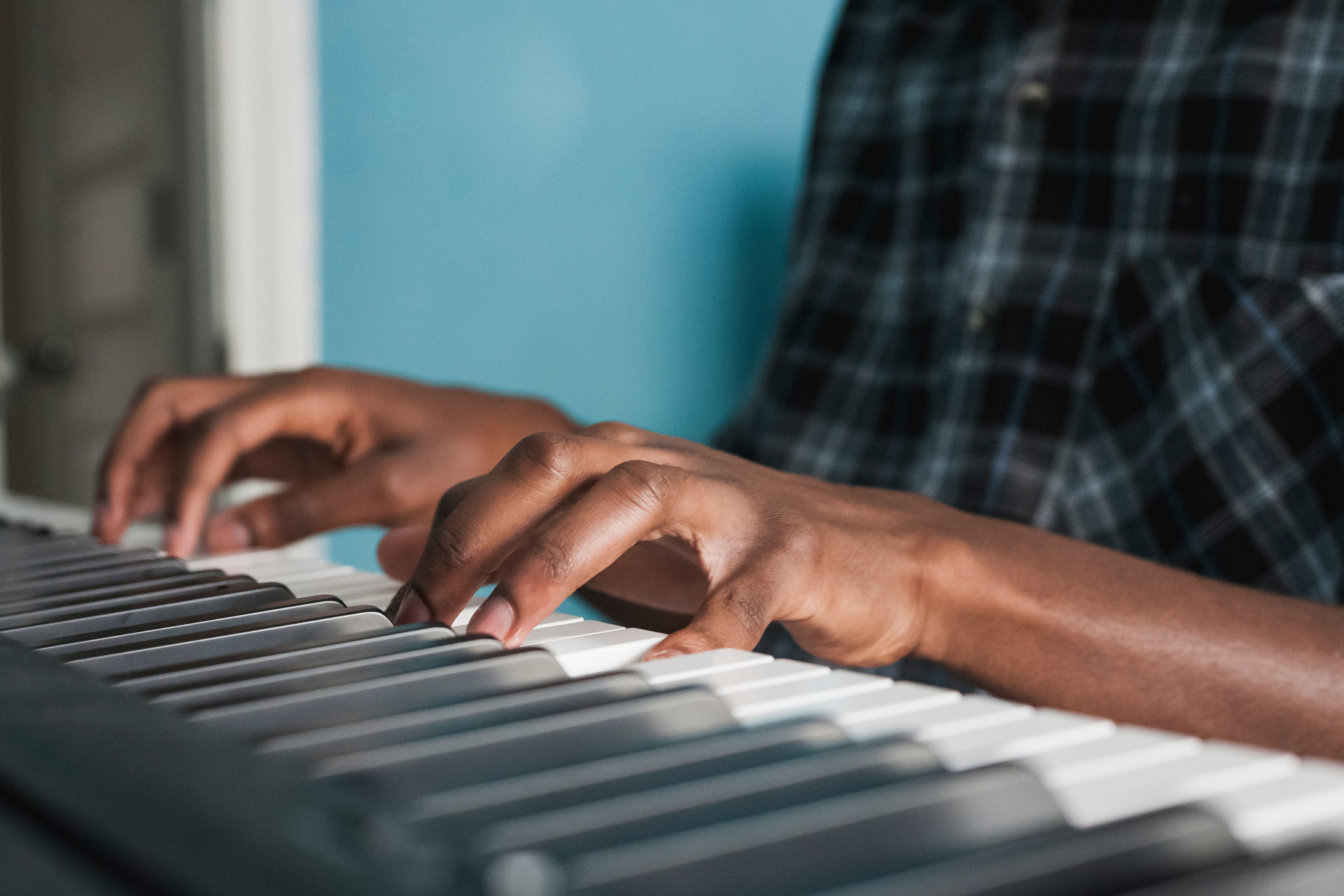 Hands are shown playing a piano.