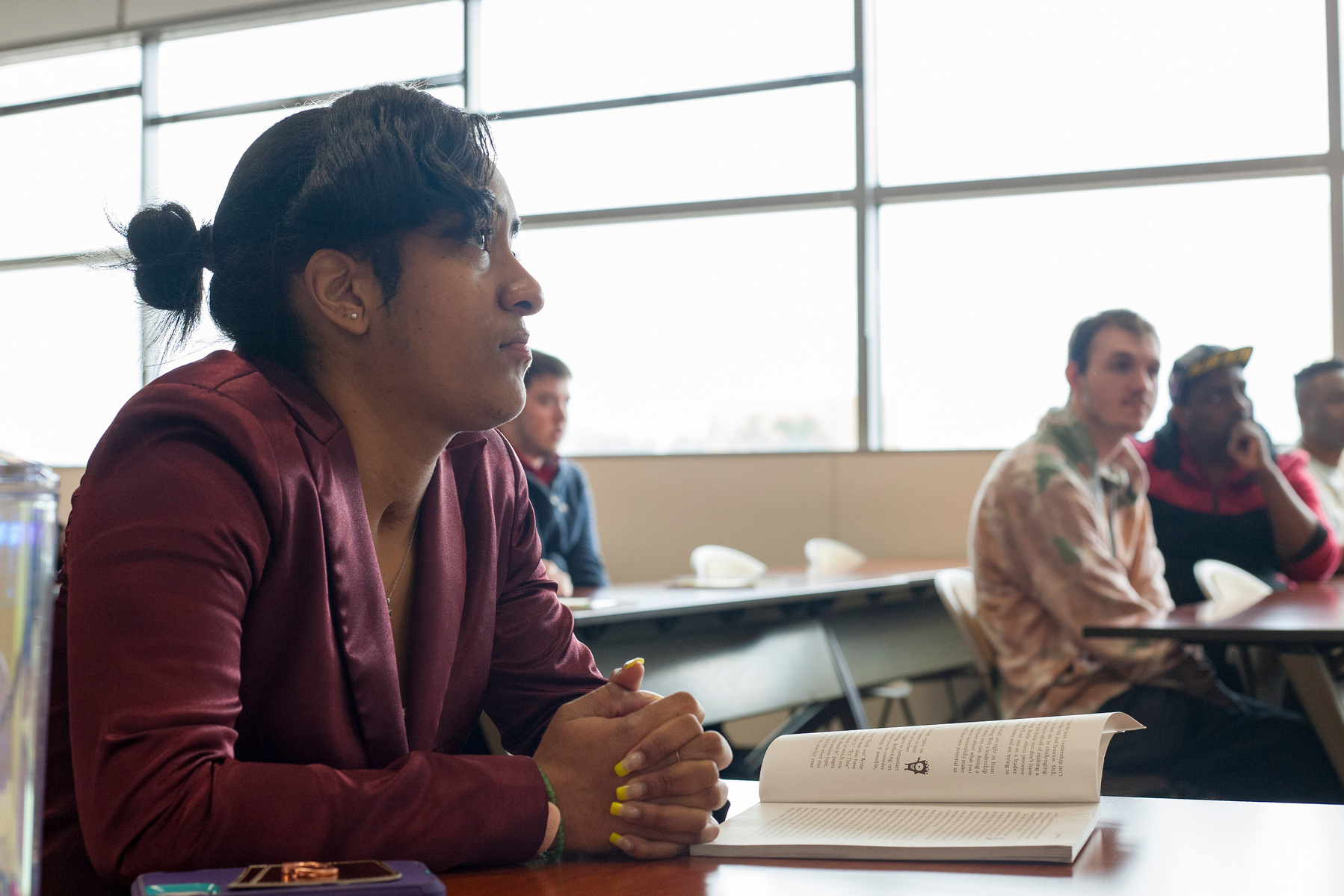 An African American female college student participates in a university class. 
